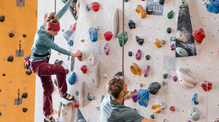 Zwei Personen bouldern nebeneinander an einer Boulderwand | © DAV/Marisa Koch