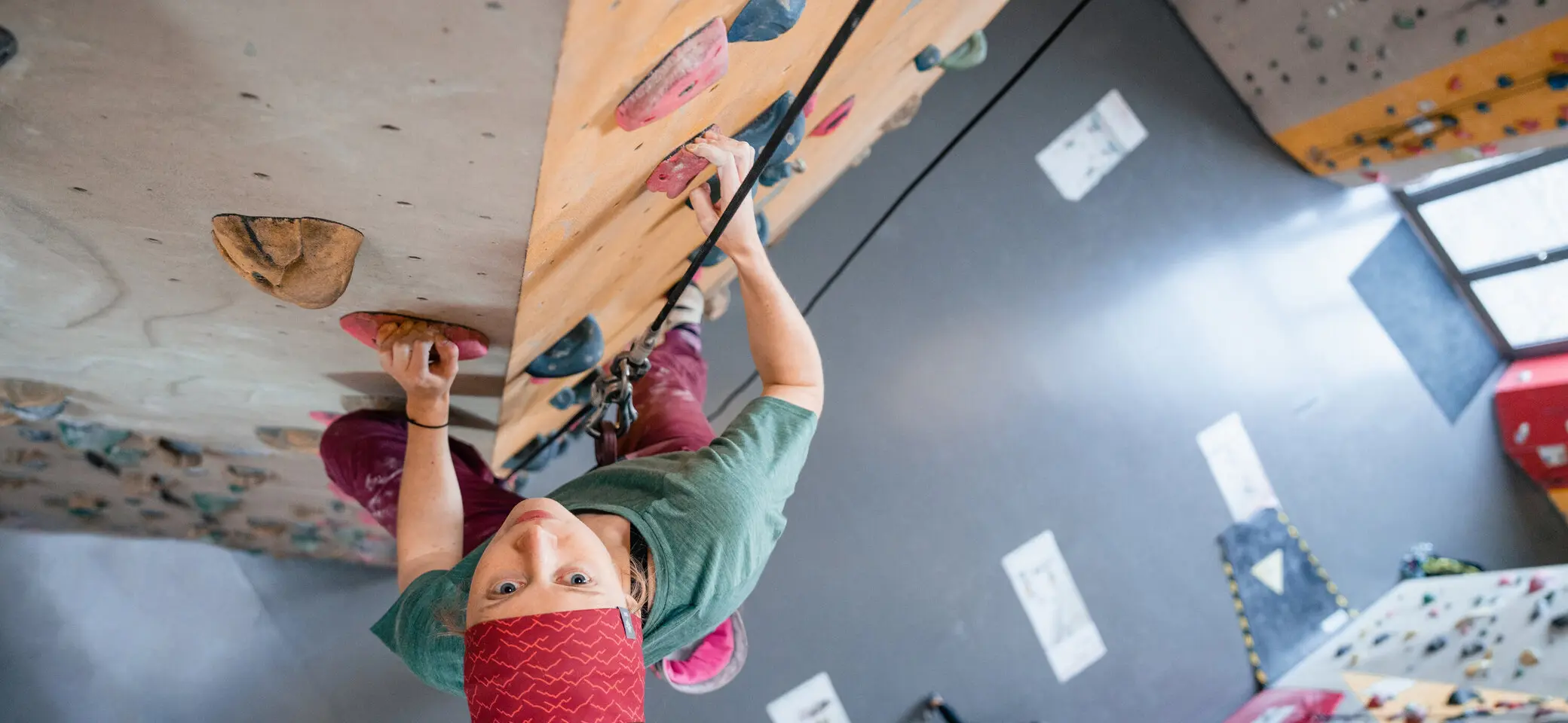Eine Frau klettert in einer Kletterhalle, ihr Partner sichert sie. | © DAV/Marisa Koch